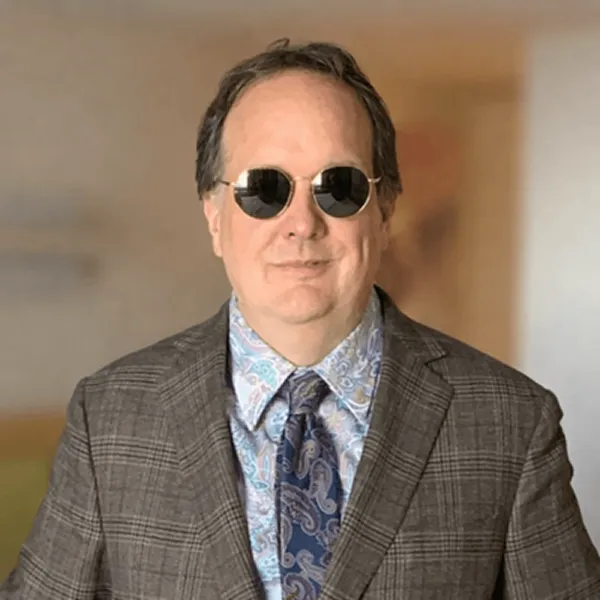 Loren Coleman, Creative Partner and IP Advisor, in sunglasses and a checked tweed jacket